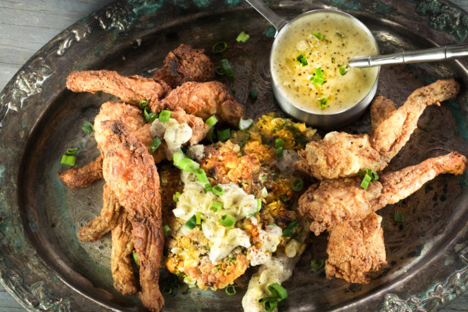 A platter of Buttermilk Fried Frog Legs goes perfectly with corn cakes and a mustard sauce in this classic Cajun recipe.