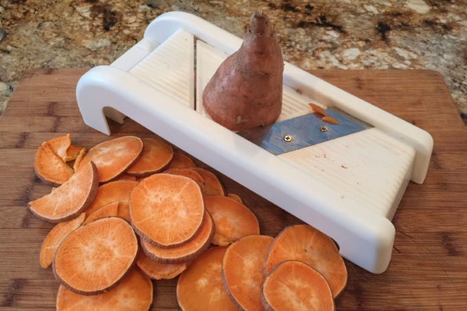 Slicing with a mandoline. Slicing uniform rounds with a kitchen mandoline is easy for this Cajun recipe.