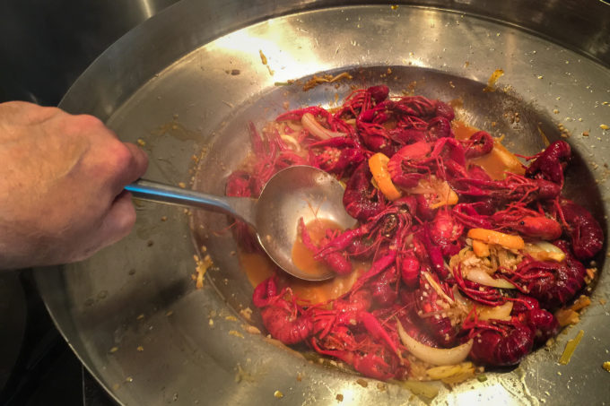 Step 2: A quick turn in a wok layers on the buttery, garlic-infused sauce of my Two-Step Boiled Louisiana Crawfish.