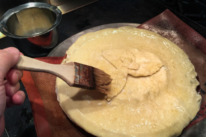 Brushing the crust on my Bacon Jam Baked Brie Bacon Jam Baked Brie done in a Cajun recipe.
