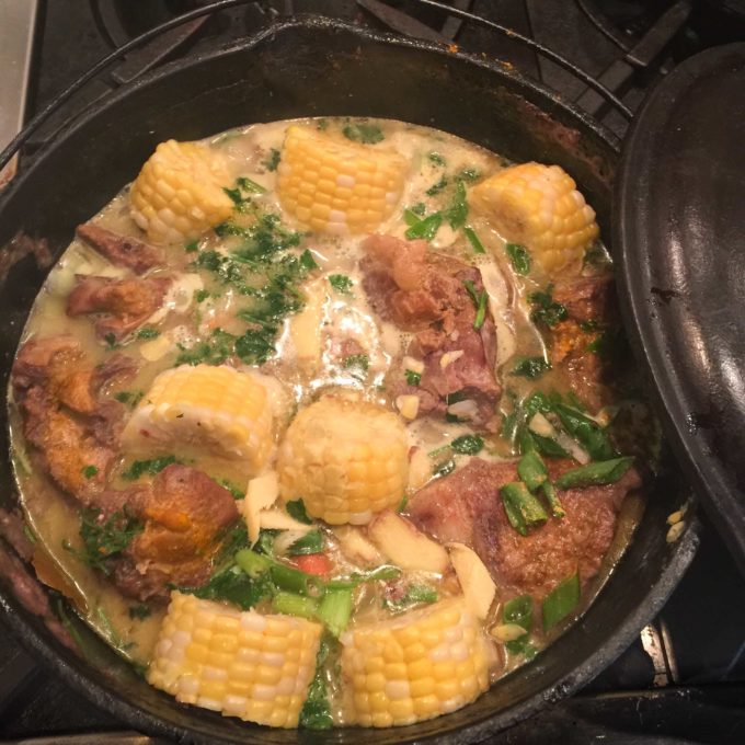 Pork curry cooked in a black iron pot.