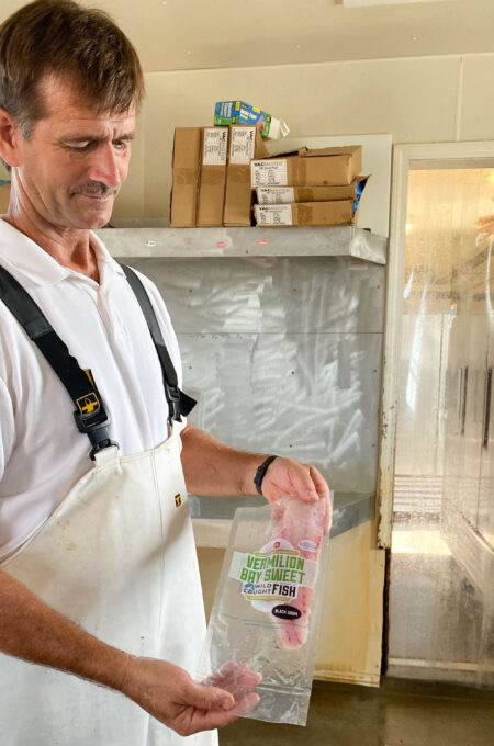 Douglas packages a black drum fillet just before vacuum-packing for Vermilion Bay Sweet. (Photo credit: George Graham)